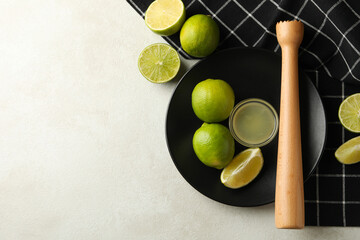 Concept of healthy food with ripe limes on white textured background