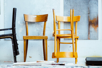 stacks of wooden chairs in front of white wall