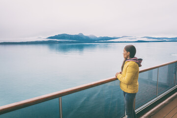 Fototapeta premium Alaska cruise travel tourist looking at mountains landscape from balcony deck of ship. Inside passage Glacier bay scenic vacation travel woman enjoying scenery from boat.