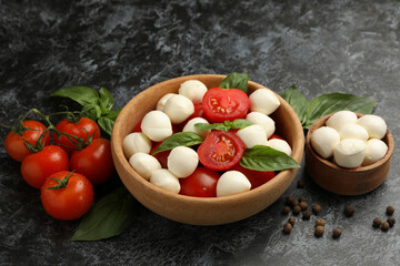 Concept of tasty eating with mozzarella cheese on black smokey background