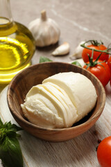 Concept of tasty eating with mozzarella and ingredients on board on gray textured table