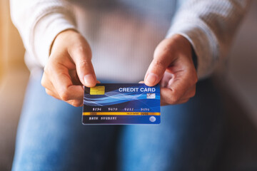 Closeup image of a woman holding and showing credit card