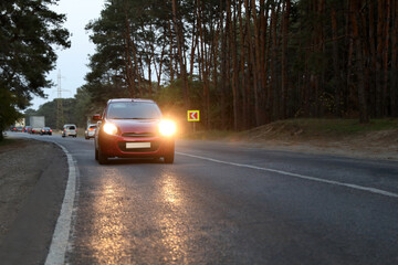 Red car on highway near wood. Road trip