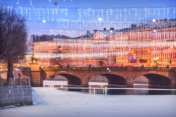 Anichkov bridge over the Fontanka river and New Year decorations in the sky of St. Petersburg