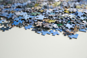Puzzle pieces on white table, closeup view