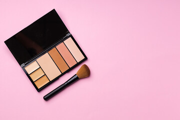 Make up palette with brush on pink background