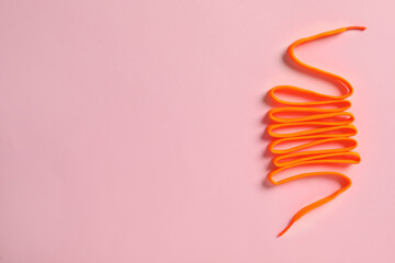 Orange shoelace on pink background, top view. Space for text - obrazy, fototapety, plakaty