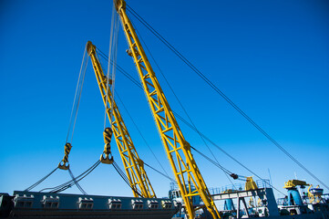 Loading in port. Floating port crane on blue sky background