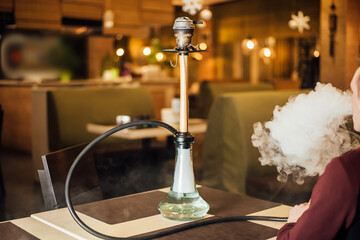 man smoking hookah in a restaurant