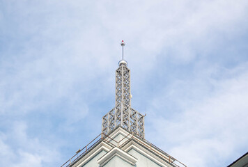 Bottom view of the iron tower of the airport with a red lamp in the bright sky