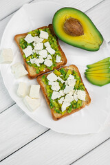 Tasty avocado sandwiches on table
