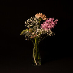 Bouquet of flowers in a vase on a black background
