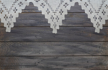  Crocheted tablecloth on an old wooden background. The subject of needlework is a knitted napkin. Vintage interior item. Copyspace. Wedding, Easter concept.