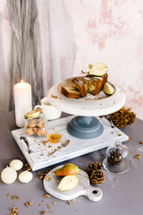 The biscuit cake is cut into cubes with pear, walnut and honey, lies on a cake plate and a tray. Idea for setting a holiday and a sweet table.