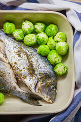 Raw dorado fish with Brussels sprouts for cooking