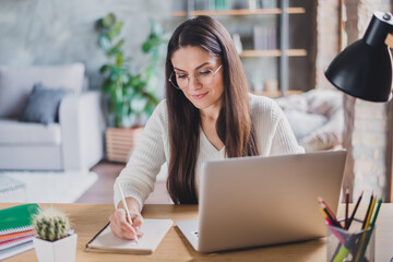 Photo of beautiful attractive happy positive smiling focused calm woman writing in notebook working...