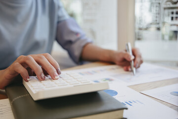 Fototapeta premium Financial businesswoman calculating corporate income tax data And analyzing charts of financial stocks that are in good condition with growth and progress, Investment in finance.