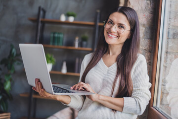 Photo of attractive charming lovely pretty happy positive cheerful smiling woman in glasses working in laptop at home house
