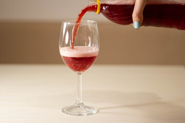 Cherry beer from a plastic bottle pours into a glass