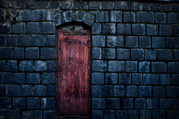 fragment of a vintage burgundy door with a yellow handle, cracks and scratches, cracked paint