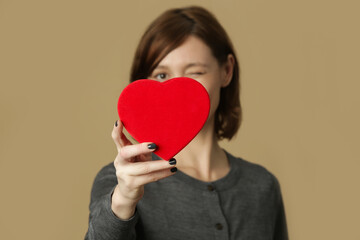 Portrait of young woman with red heart shaped gift box. Happiness, valentines day and love concept.