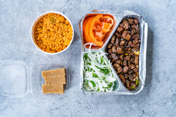 Turkish Take Away Kebab Liver with Onions and Tomatoes in Tabldot Foil Plate served with Semolina Irmik Dessert and Bulgur or Bulghur Rice Pilaf Pilav.