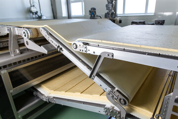 Dough on conveyor line preparing for biscuits making