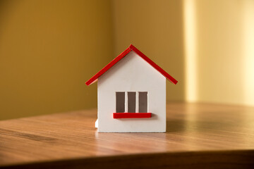 house in winter - heating system concept and cold snowy weather with model of a house wearing a knitted cap