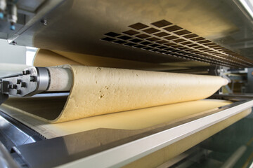 Dough on conveyor line preparing for biscuits making