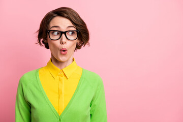 Photo of sweet excited young woman wear green cardigan spectacles looking empty space isolated pastel pink color background