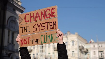 Solo picket protest in city square save the planet concept with slogan Change the System not the climate   - Powered by Adobe