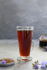 Healthy chicory beverage as coffee in glass and fresh summer blue flowers. Instant and concentrate. Vertical. Close up.