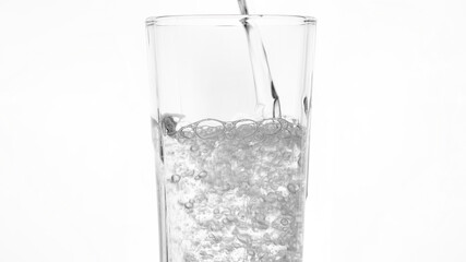 glass of water. pouring water in glass, white background. clear sparkling water