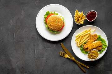 Delicious burgers with french fries and fried chicken. Flat lay, top view