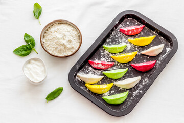 Chinese colorful raw dumplings on baking sheet, top view