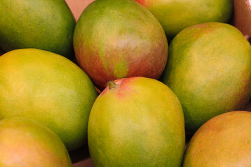 Ripe mangoes are sold in the supermarket, background