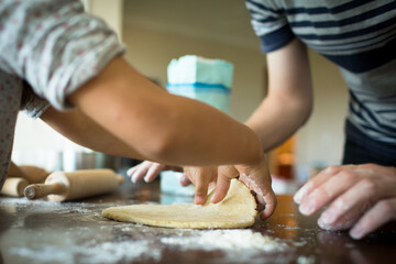 Girl's and dady's hands preparing tart dough with flour. 