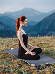 Fototapeta na wymiar Woman in leggings meditate sitting on a rug on nature in the mountains