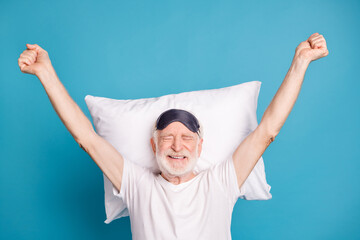 Portrait of positive aged person raise hands awake closed eyes toothy smile isolated on blue color...