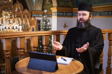 . Priest online. An Orthodox priest is recording a video for his blog. Preaching during a pandemic.