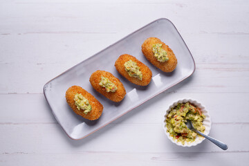 Traditional spanish croquettes tapas with avocado. Veggie tapa.