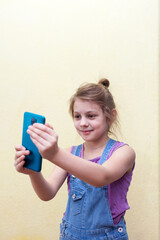 Blond girl 8 years old taking  selfie on  phone.