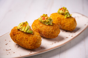 Traditional spanish croquettes tapas with avocado. Veggie tapa.