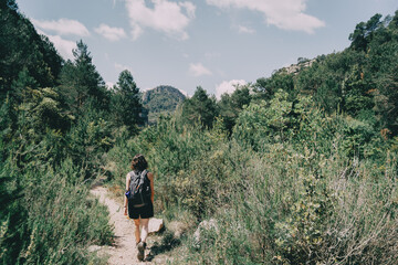 Fototapeta premium Girl walking along a small path in the mountain of Prades, Tarragona, Spain.