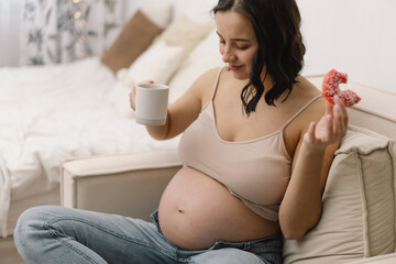 Obraz na płótnie Canvas Pregnancy and nutrition. Pregnant woman enjoying donuts and tea.