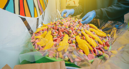 Candy shop with barrels of yellow jelly banana and strawberries  candies close up as a bright joyful background