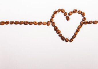 heart shaped coffee beans lined on white background