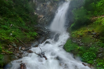 rushing splashing waterfall with fog and rain