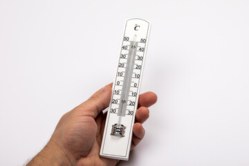 Wooden thermometer with Celsius scale in a man's hand on a white background