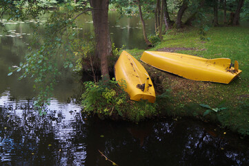 two yellow boats type kayaks lie on the banks of the lake river active water sport travel tourism beautiful summer landscape horizontal photo